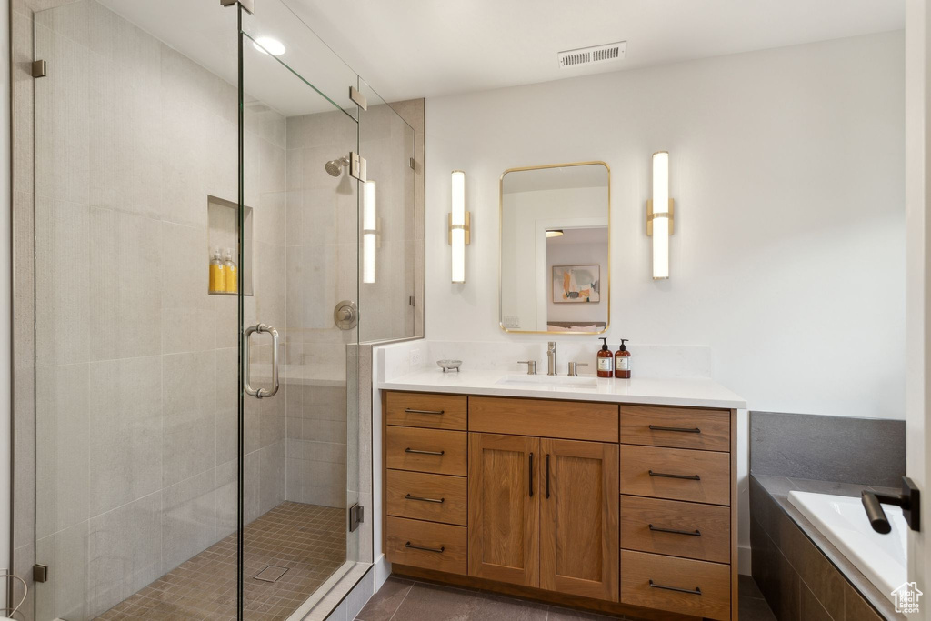 Full bath with a shower stall, vanity, tile patterned floors, and tiled tub