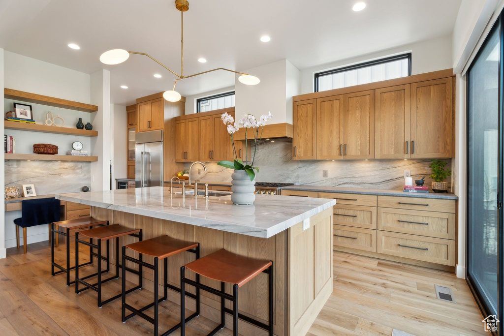 Kitchen with built in fridge, a sink, backsplash, plenty of natural light, and recessed lighting