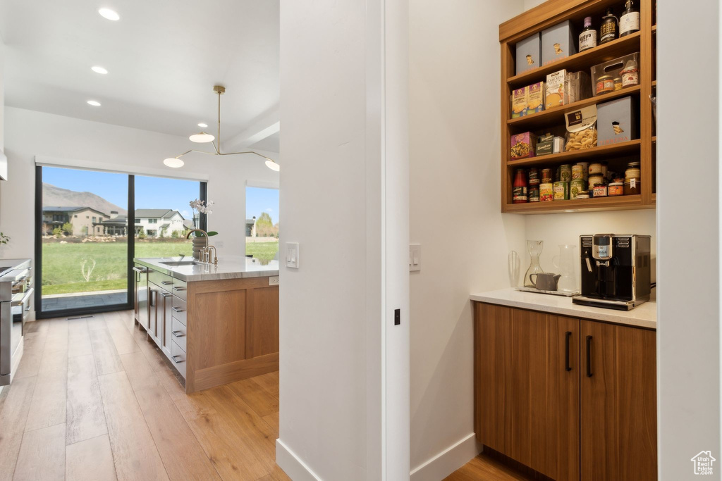 Indoor bar featuring recessed lighting, light wood-style flooring, and appliances with stainless steel finishes