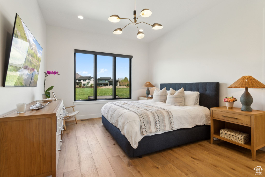 Bedroom featuring a chandelier, light wood-style flooring, baseboards, recessed lighting, and vaulted ceiling