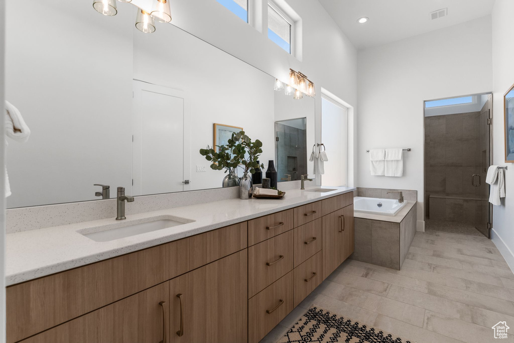Bathroom featuring double vanity, a stall shower, a bath, and recessed lighting