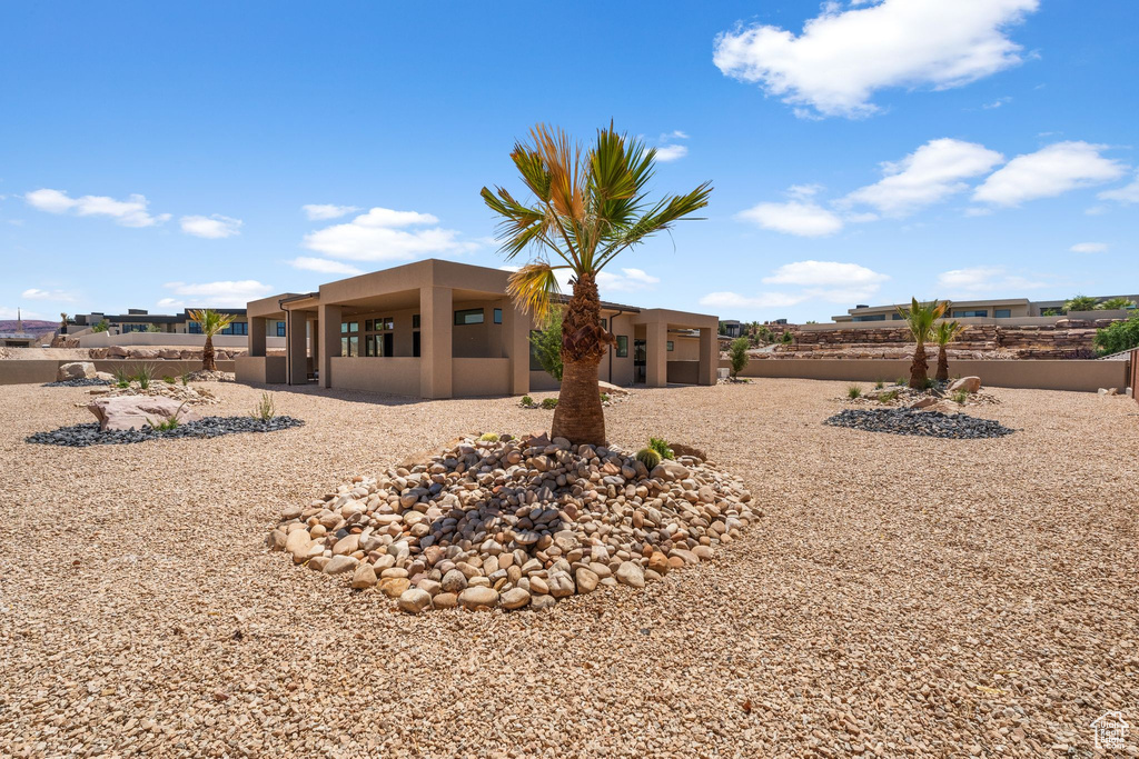 Rear view of property with stucco siding and a fenced backyard