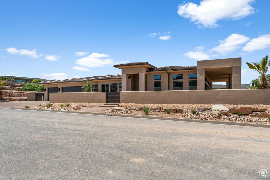 View of front of home featuring stucco siding, a garage, a tile roof, and concrete driveway