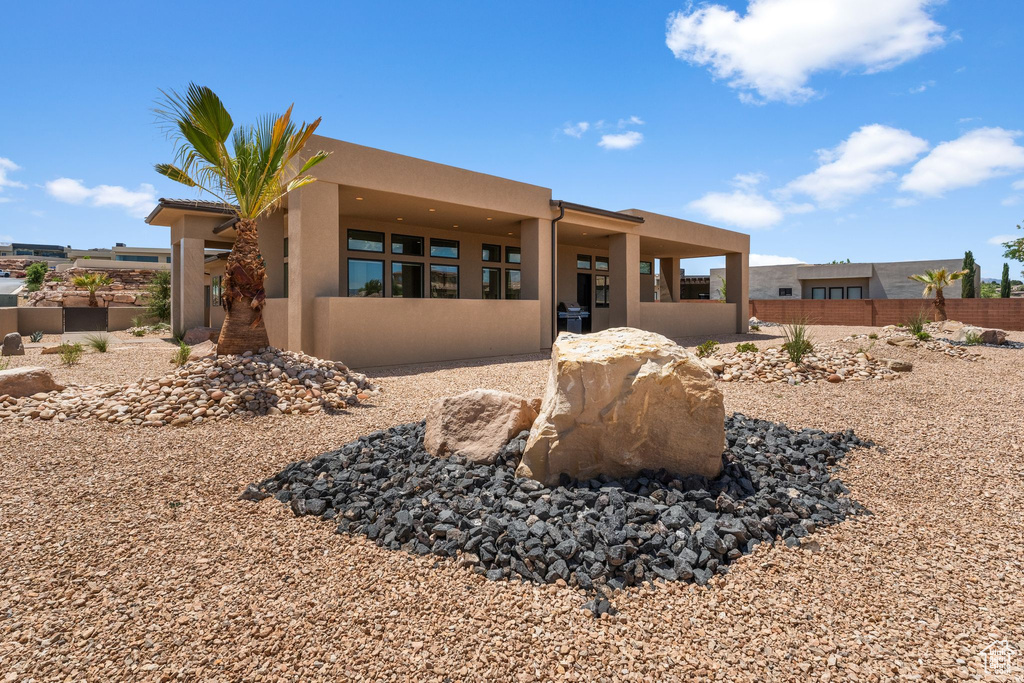 View of front of home with stucco siding and fence