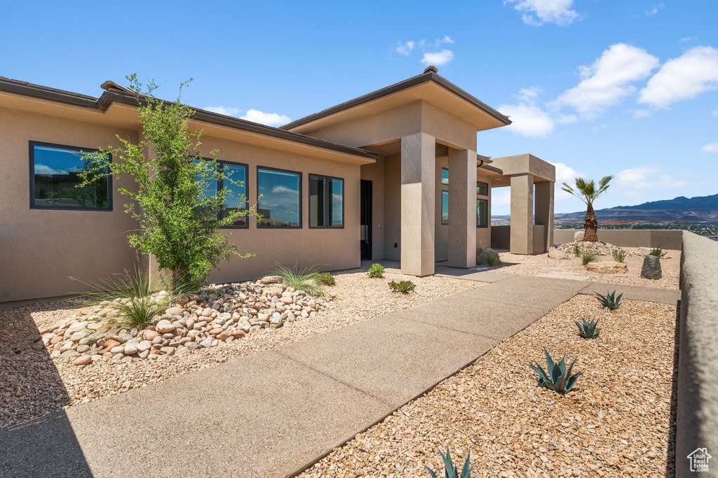View of front of house with stucco siding and a mountain view