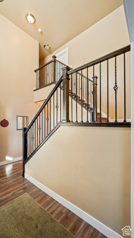 Staircase with baseboards and wood finished floors
