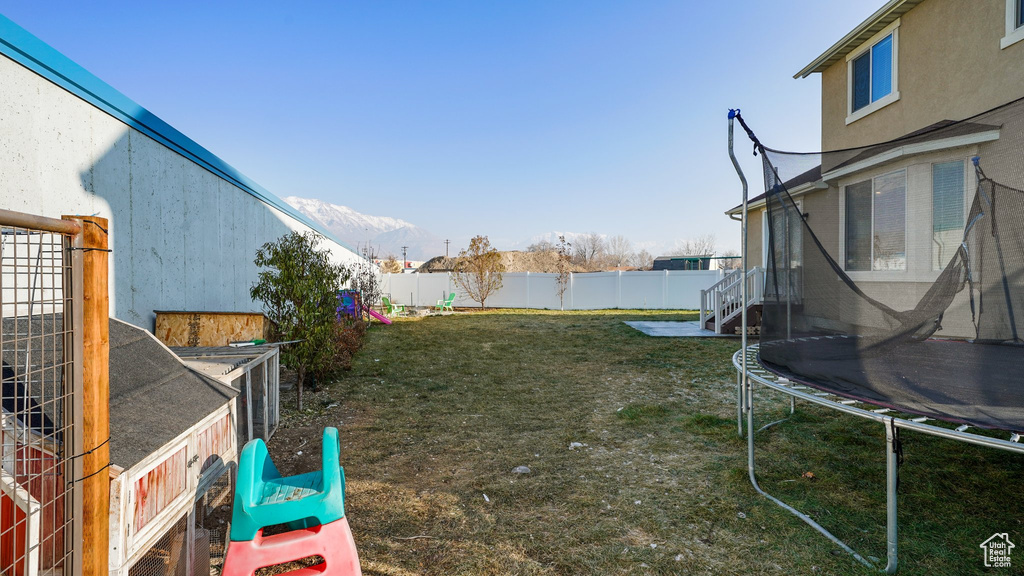 View of yard featuring a trampoline and a mountain view