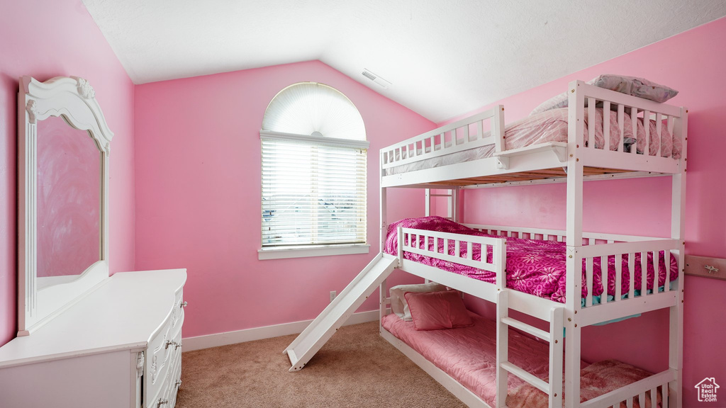 Bedroom with light carpet, lofted ceiling, and baseboards