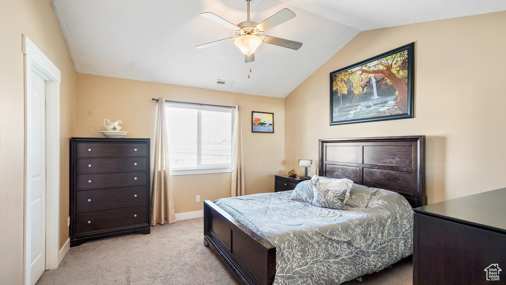 Bedroom with light carpet, vaulted ceiling, baseboards, and a ceiling fan