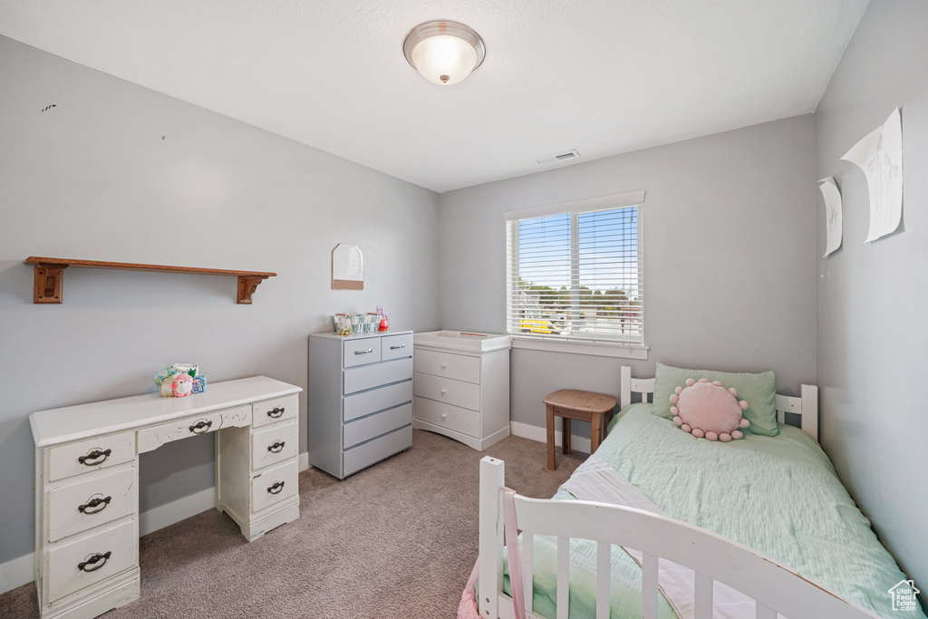 Bedroom with light colored carpet and baseboards