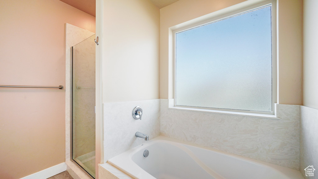 Full bath featuring a shower stall and a garden tub