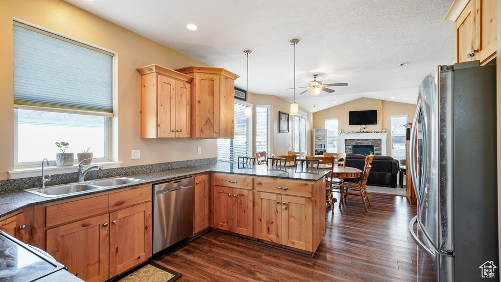 Kitchen featuring appliances with stainless steel finishes, ceiling fan, a sink, a peninsula, and dark wood finished floors