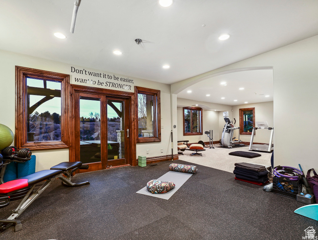 Workout area with arched walkways, baseboards, and recessed lighting