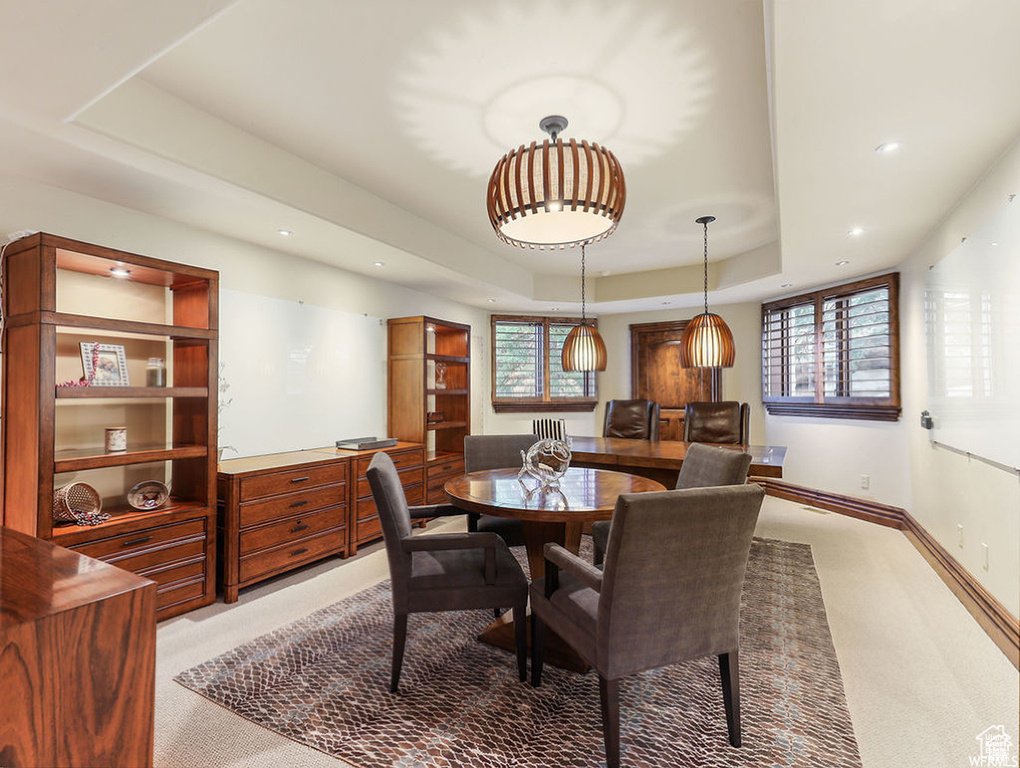 Dining space featuring a tray ceiling, baseboards, light carpet, and recessed lighting
