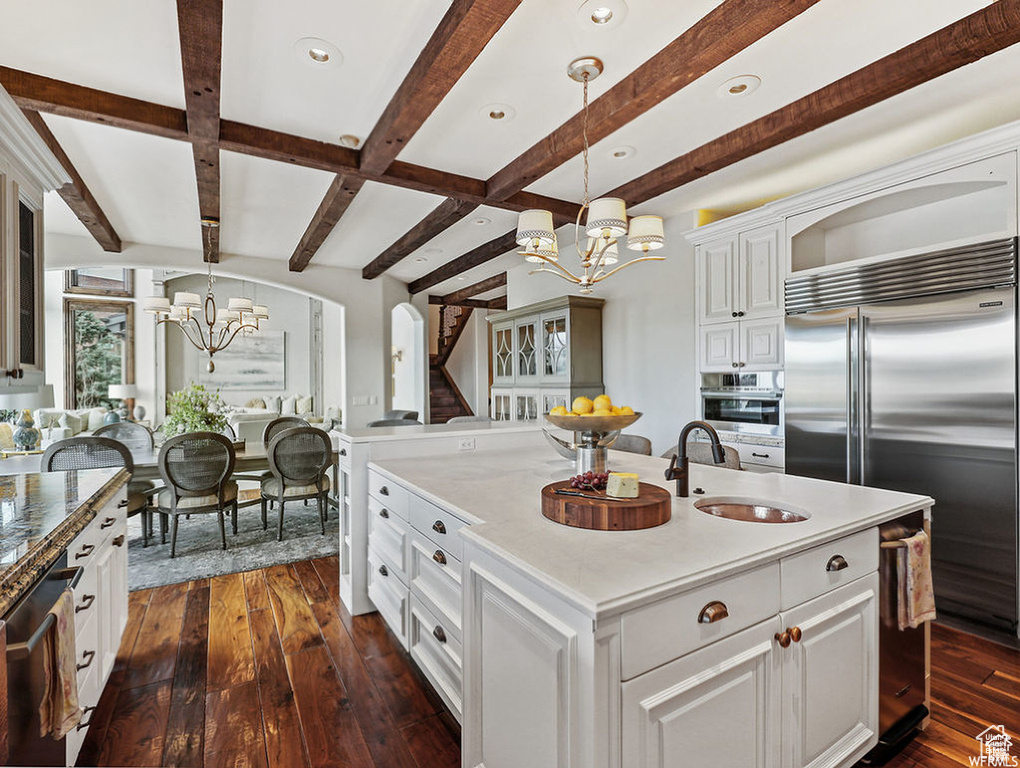 Kitchen featuring an inviting chandelier, a sink, stainless steel appliances, and dark wood finished floors