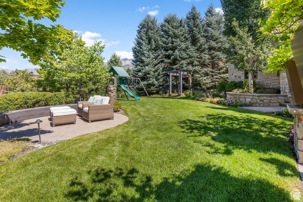 View of yard with an outdoor hangout area, a patio, and a playground
