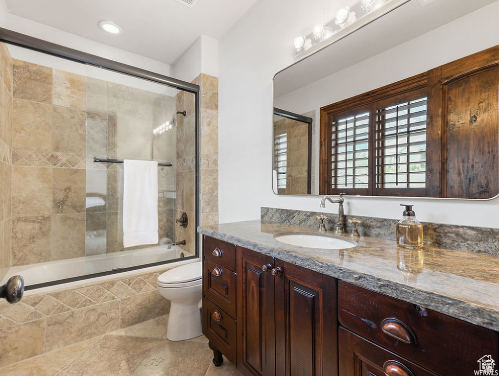 Bathroom with toilet, tiled shower / bath combo, recessed lighting, and vanity