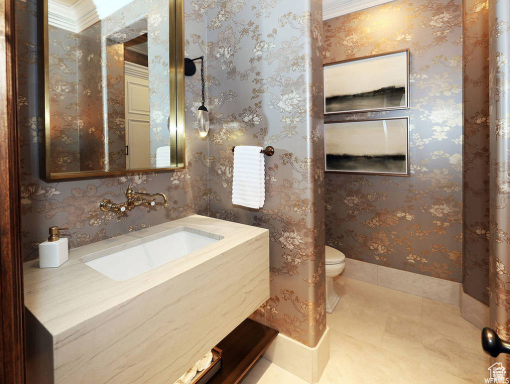 Bathroom featuring wallpapered walls, toilet, tile patterned floors, and vanity