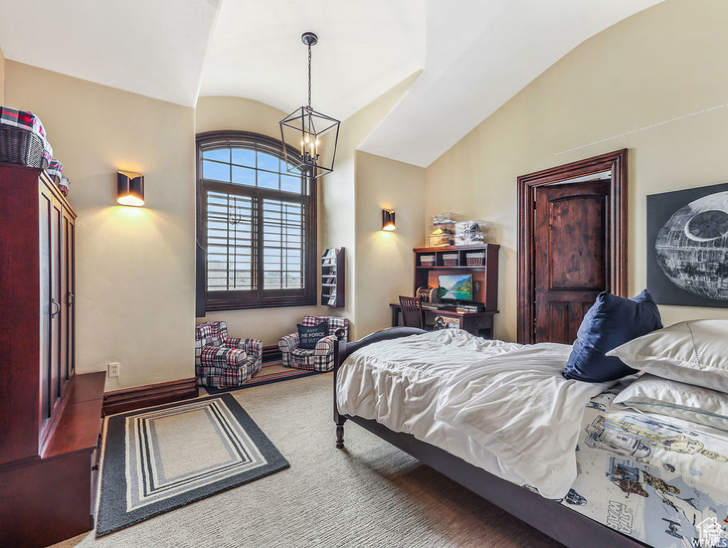 Bedroom featuring a notable chandelier, carpet flooring, and vaulted ceiling