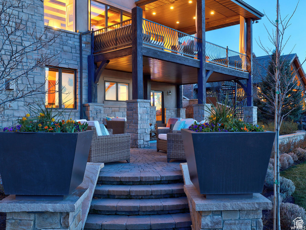 View of patio featuring a balcony and stairway