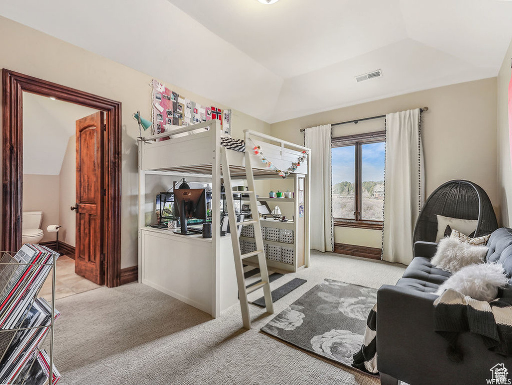 Carpeted bedroom featuring baseboards, vaulted ceiling, and visible vents