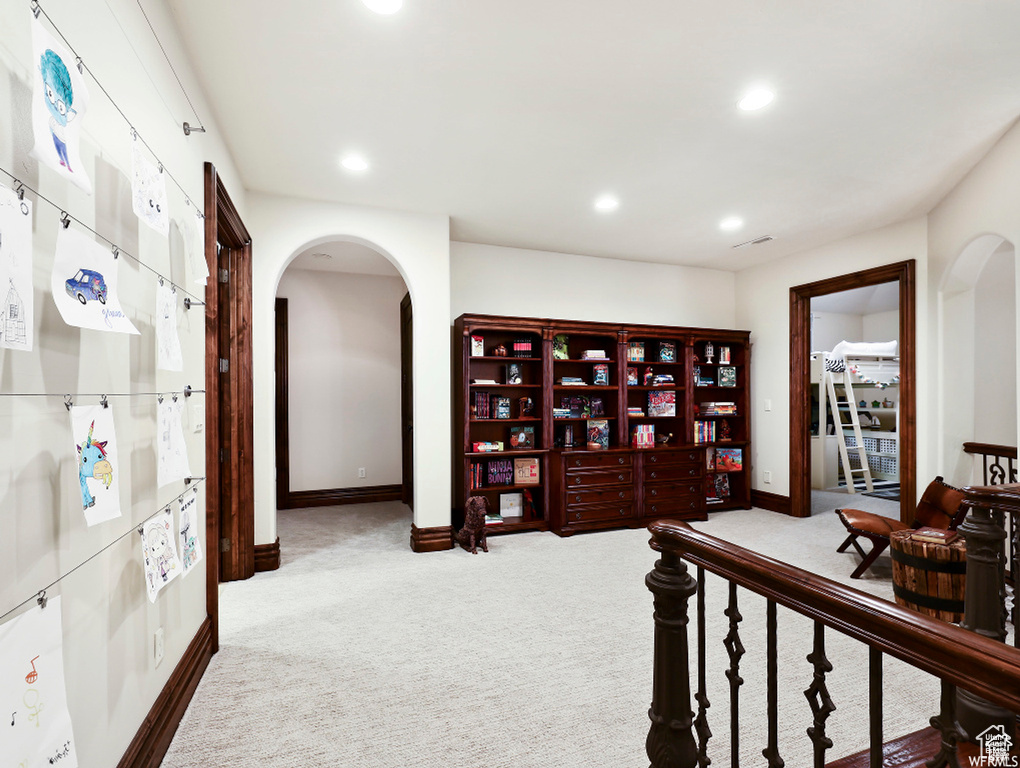 Hallway featuring baseboards, arched walkways, carpet floors, and recessed lighting