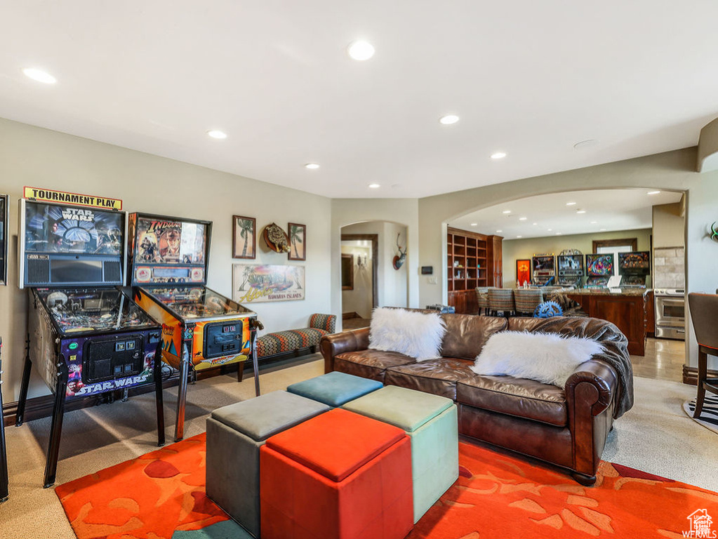 Living area with carpet flooring, arched walkways, and recessed lighting