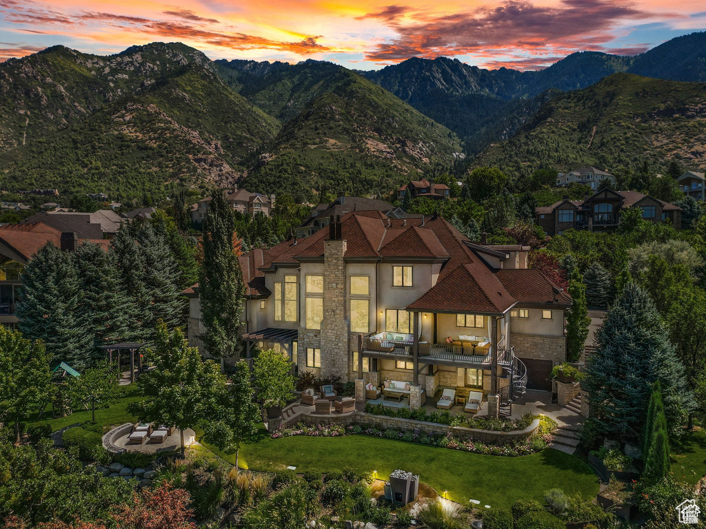 Exterior space featuring stone siding, stucco siding, a mountain view, and a patio