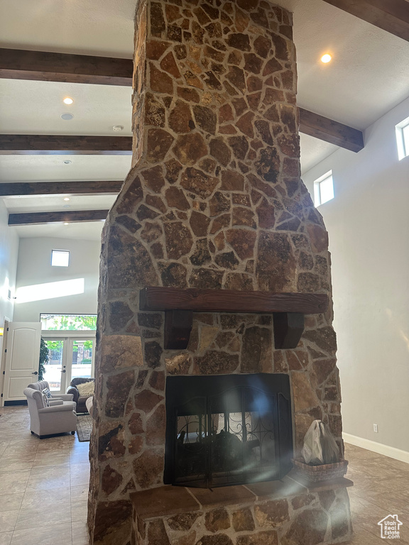 Detailed view of beam ceiling, a fireplace, and baseboards