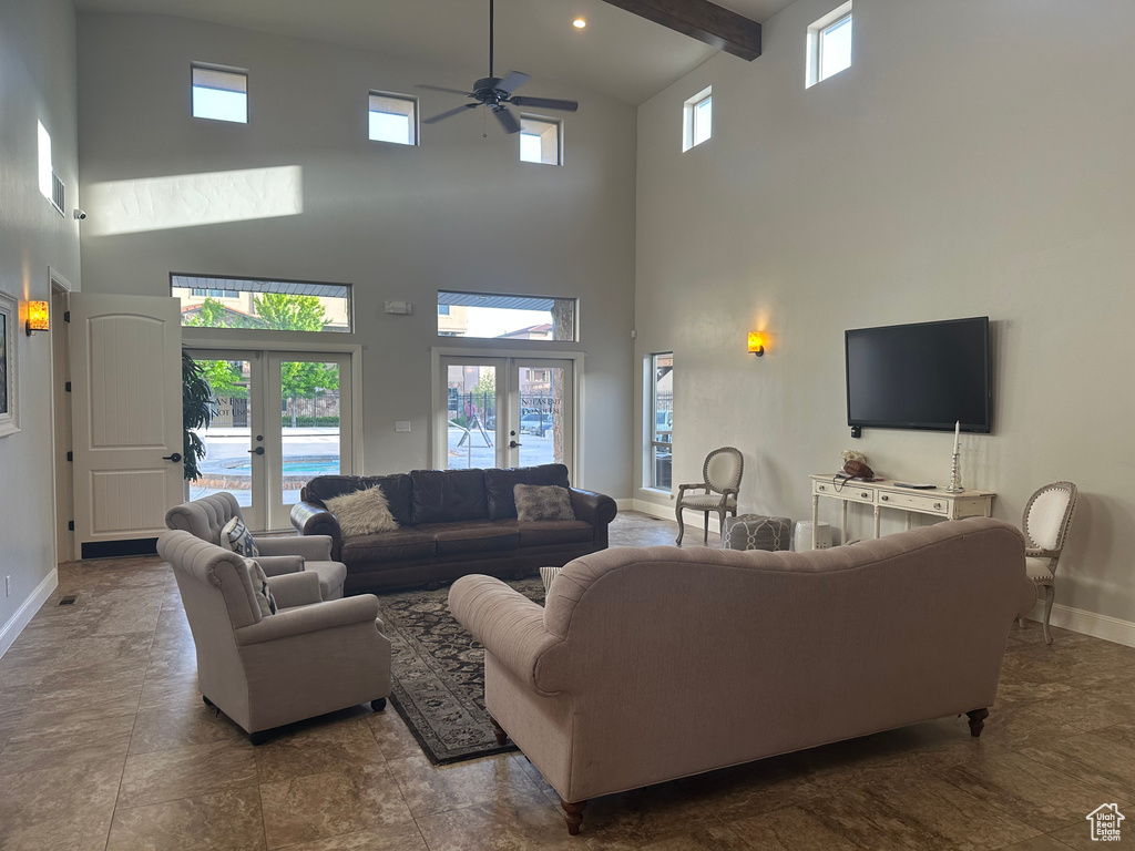 Living room with french doors, a high ceiling, baseboards, and ceiling fan