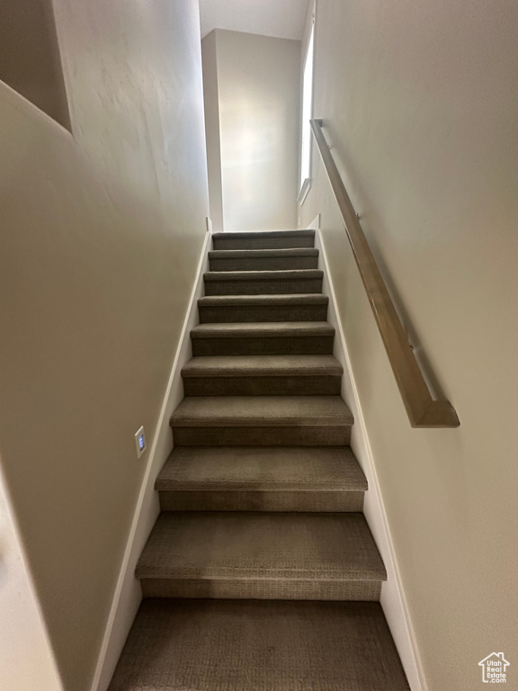 Stairway featuring carpet flooring and baseboards