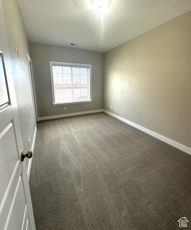 Carpeted empty room with baseboards