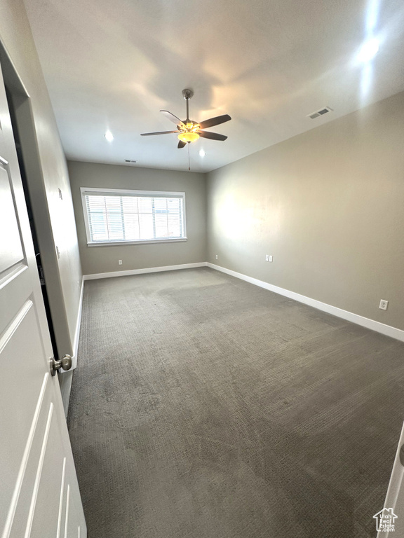 Unfurnished room featuring dark colored carpet, a ceiling fan, baseboards, and recessed lighting