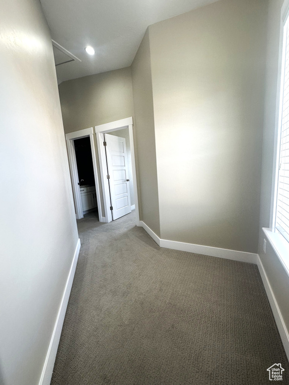 Unfurnished room with carpet floors, baseboards, and attic access
