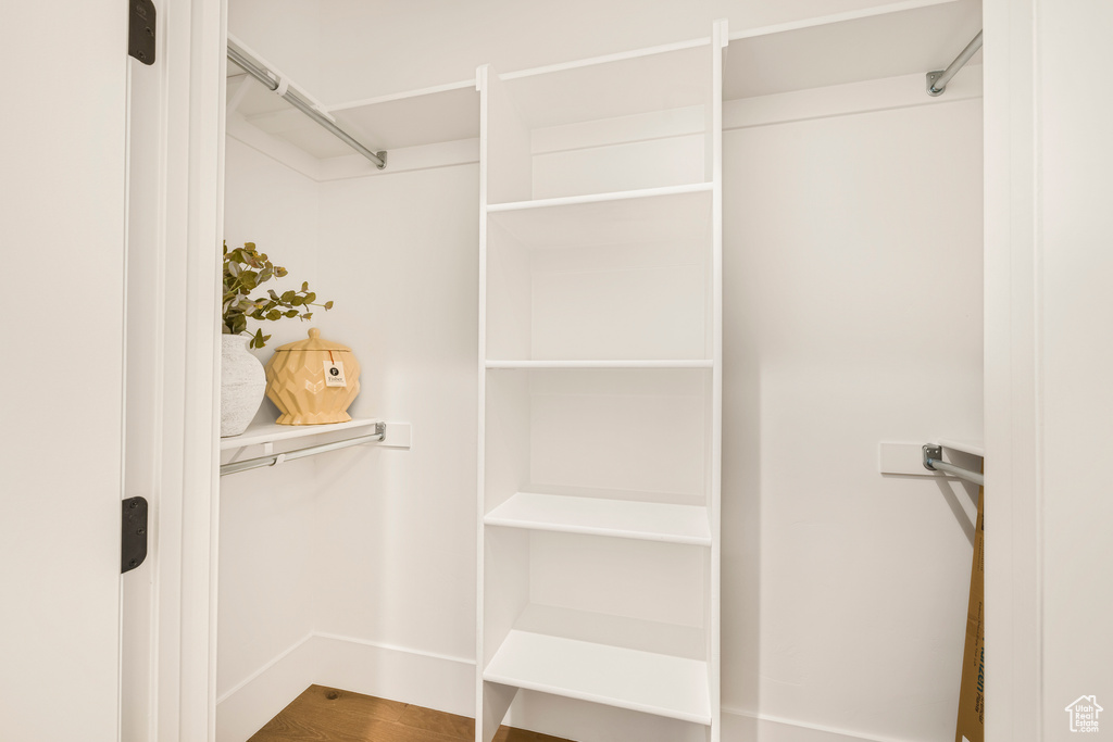 Walk in closet with wood finished floors