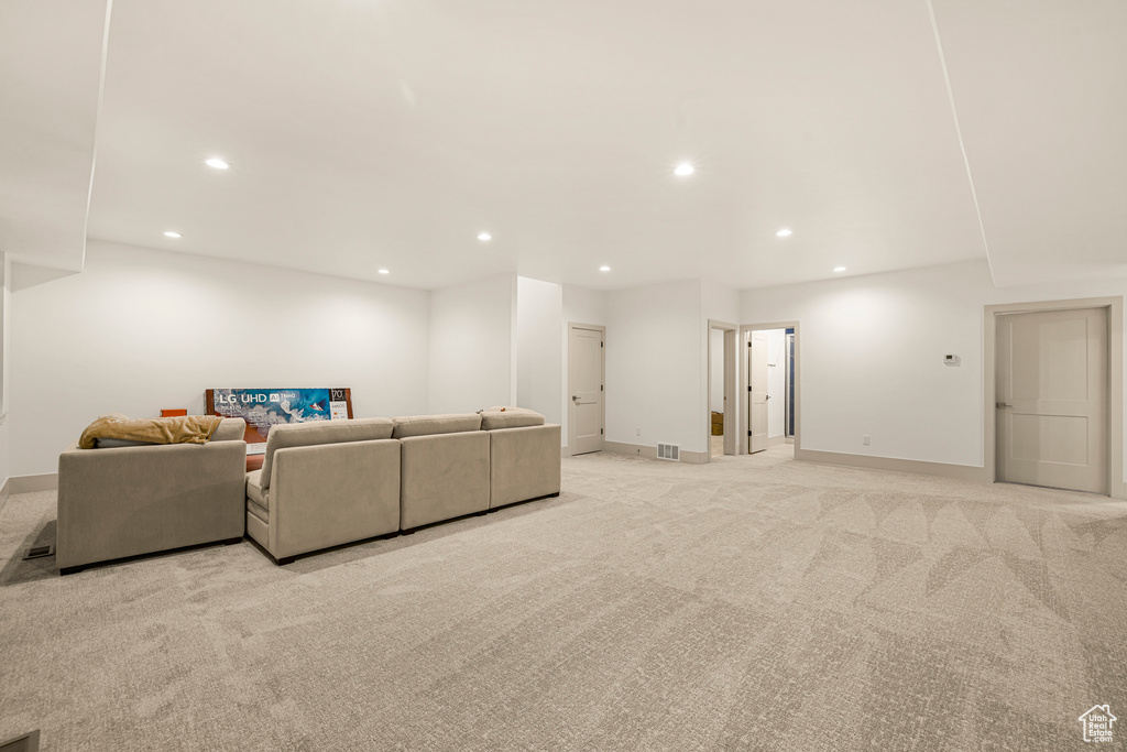 Living area featuring light colored carpet, recessed lighting, and baseboards