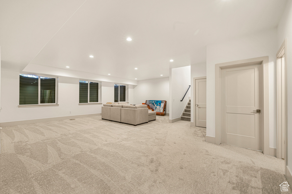 Living area with carpet flooring, recessed lighting, baseboards, and stairway