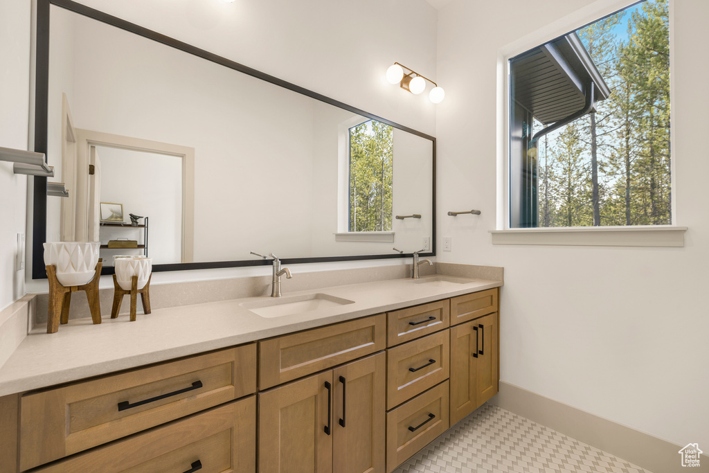 Bathroom featuring double vanity and healthy amount of natural light
