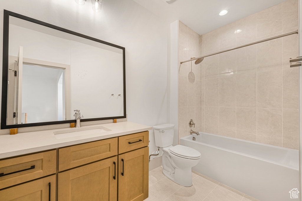 Full bathroom featuring toilet, tile patterned floors, vanity, and  shower combination