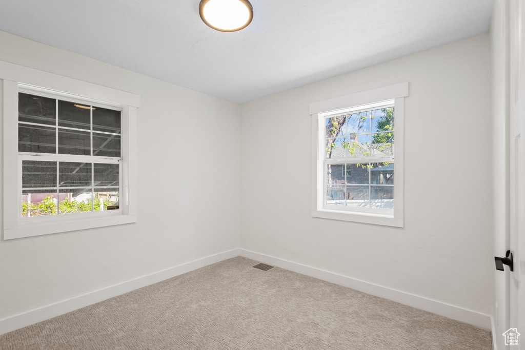 Carpeted empty room with baseboards
