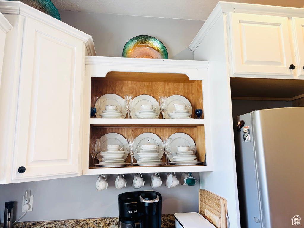 Kitchen view of freestanding refrigerator and white cabinetry