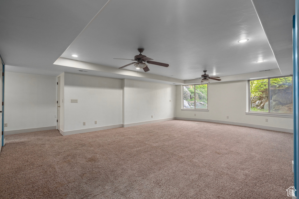 Carpeted spare room with baseboards, a ceiling fan, recessed lighting, and a raised ceiling