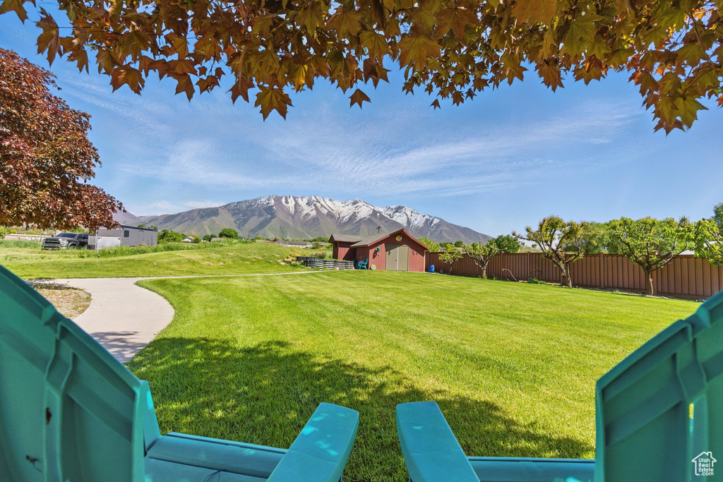 View of yard featuring a mountain view, an outdoor structure, and a storage shed
