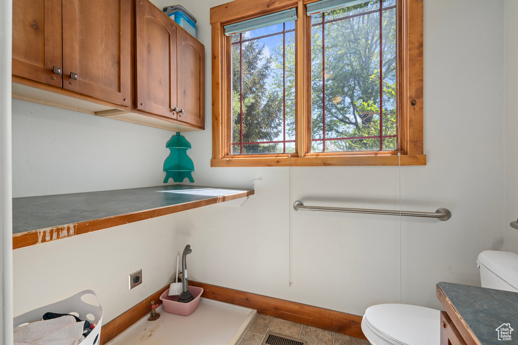 Bathroom with toilet, baseboards, and vanity