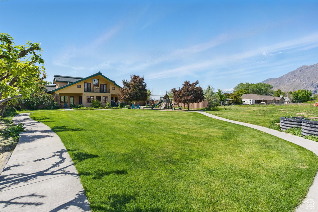 View of community featuring a mountain view and a yard