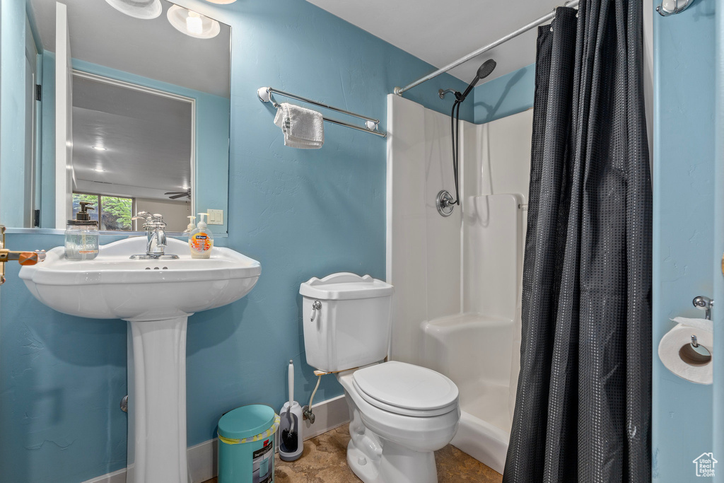 Full bath with a shower with shower curtain and toilet