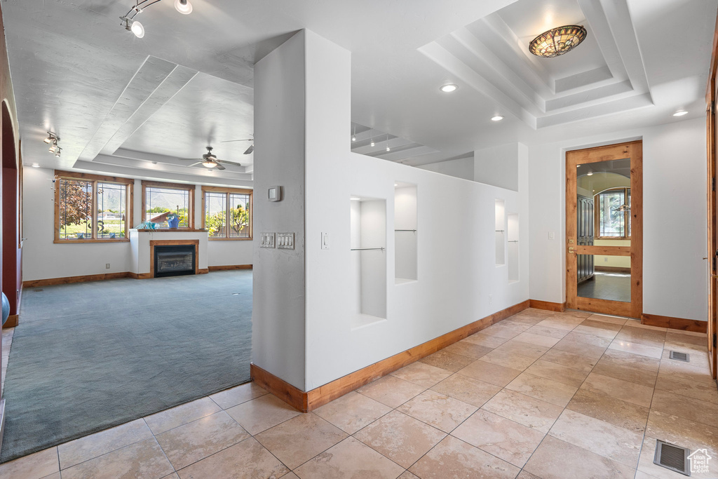 Hall with a raised ceiling, light carpet, baseboards, and recessed lighting