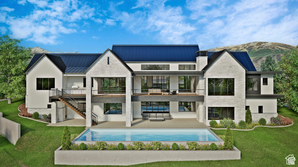Back of property featuring a balcony, a standing seam roof, a yard, metal roof, and a patio