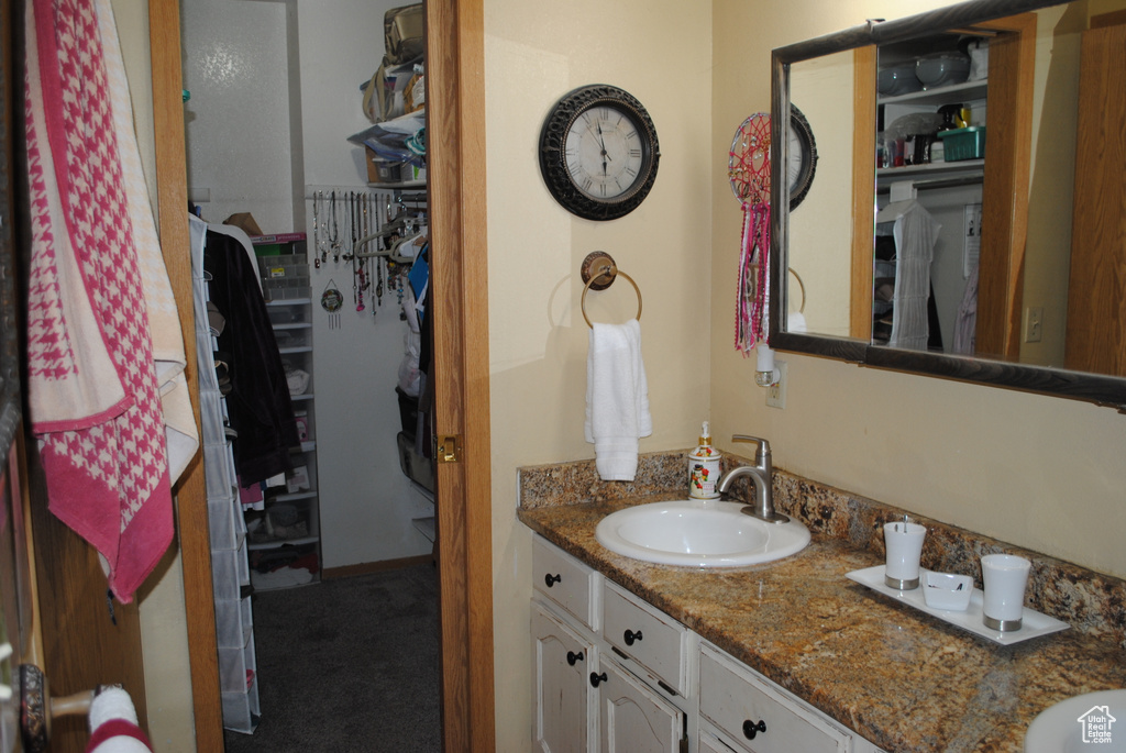 Bathroom with vanity and a walk in closet
