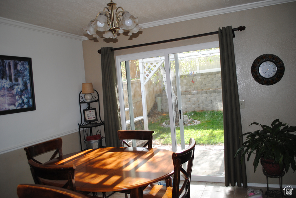 Dining area with a chandelier, ornamental molding, and light tile patterned floors